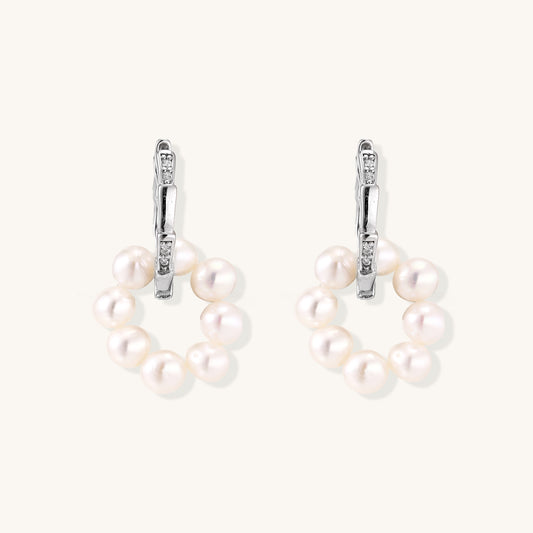 Sterling silver huggie hoop earrings with clustered white freshwater pearls and crystal accents on white background.