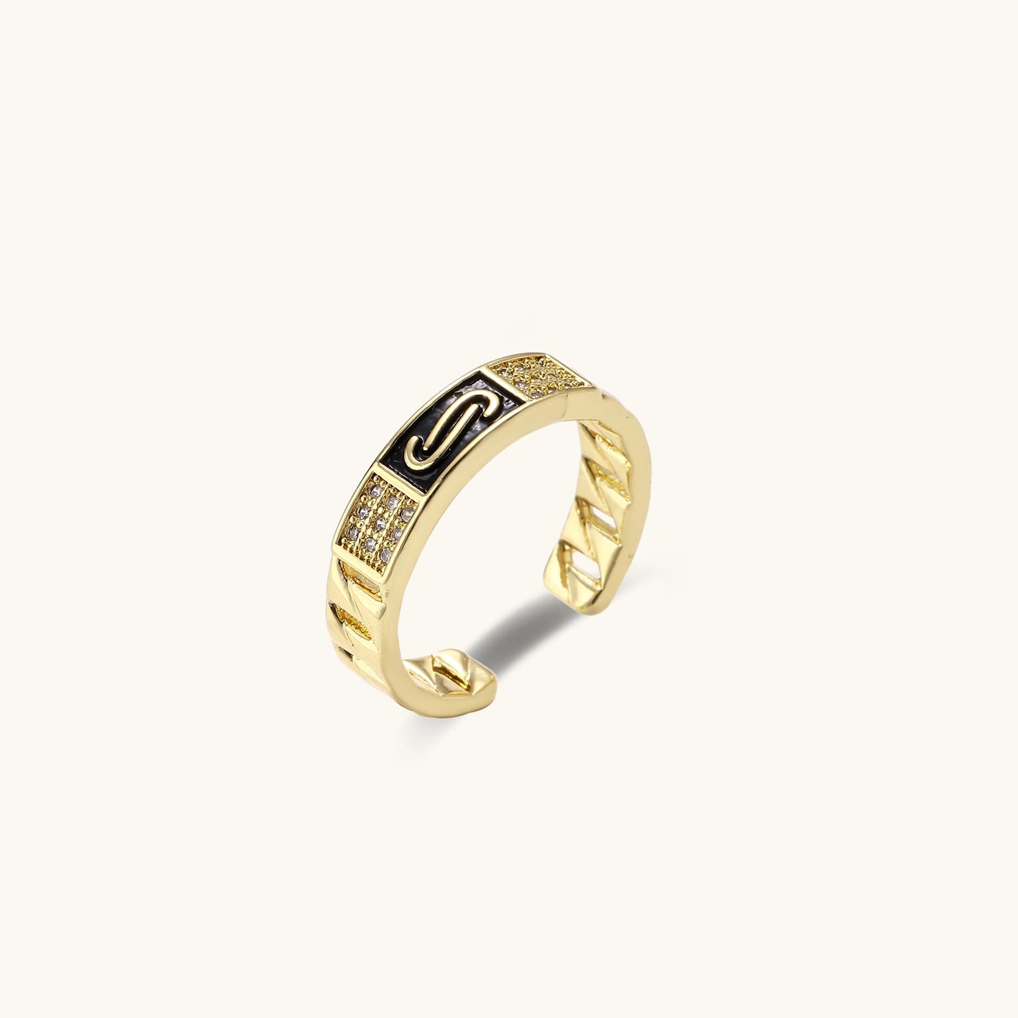 Two gold-plated brass rings with chain-link bands, one featuring a round cubic zirconia halo, one with black enamel accent.