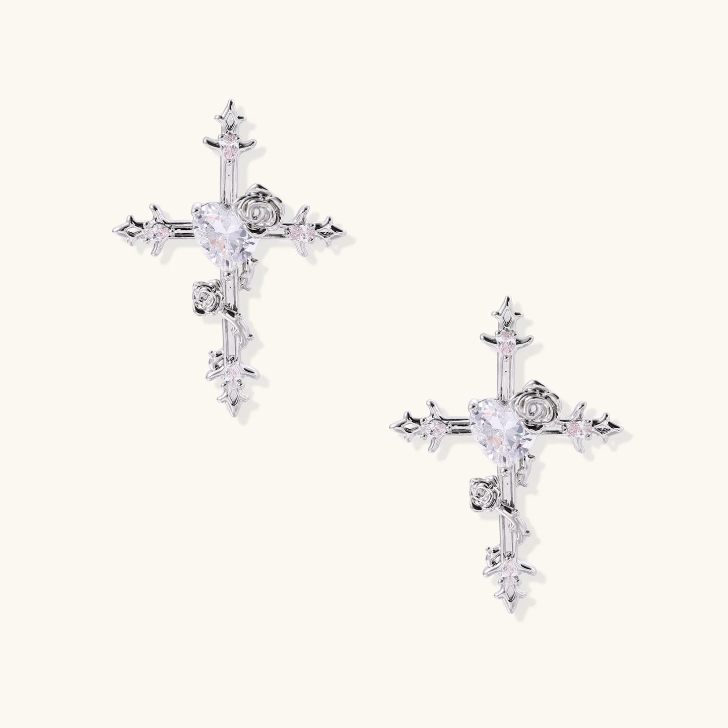 Two-tone cross earrings with gold roses and crystal stars on silver hoops, dangle drop style on white background.