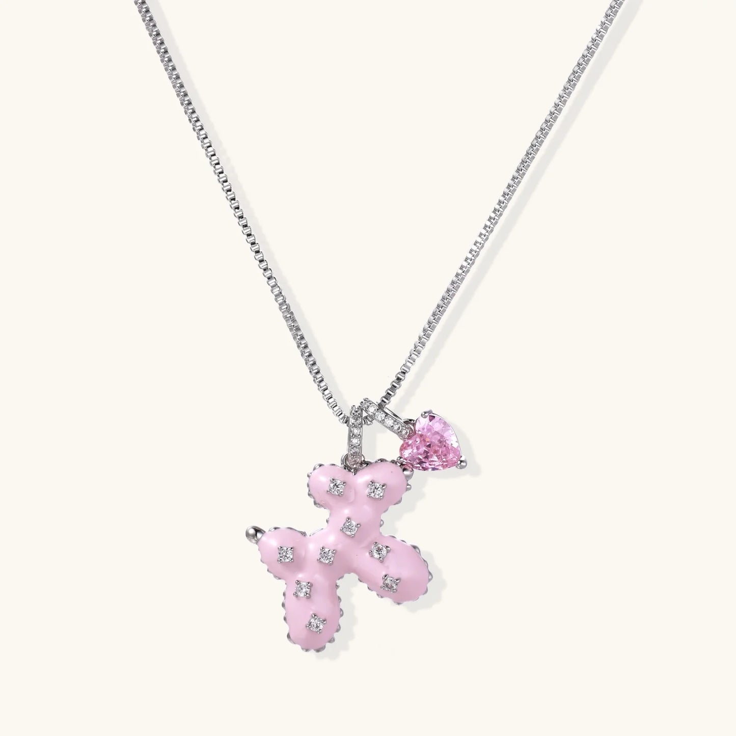 Pink enamel teddy bear pendant with crystal accents and heart charm on white gold chain