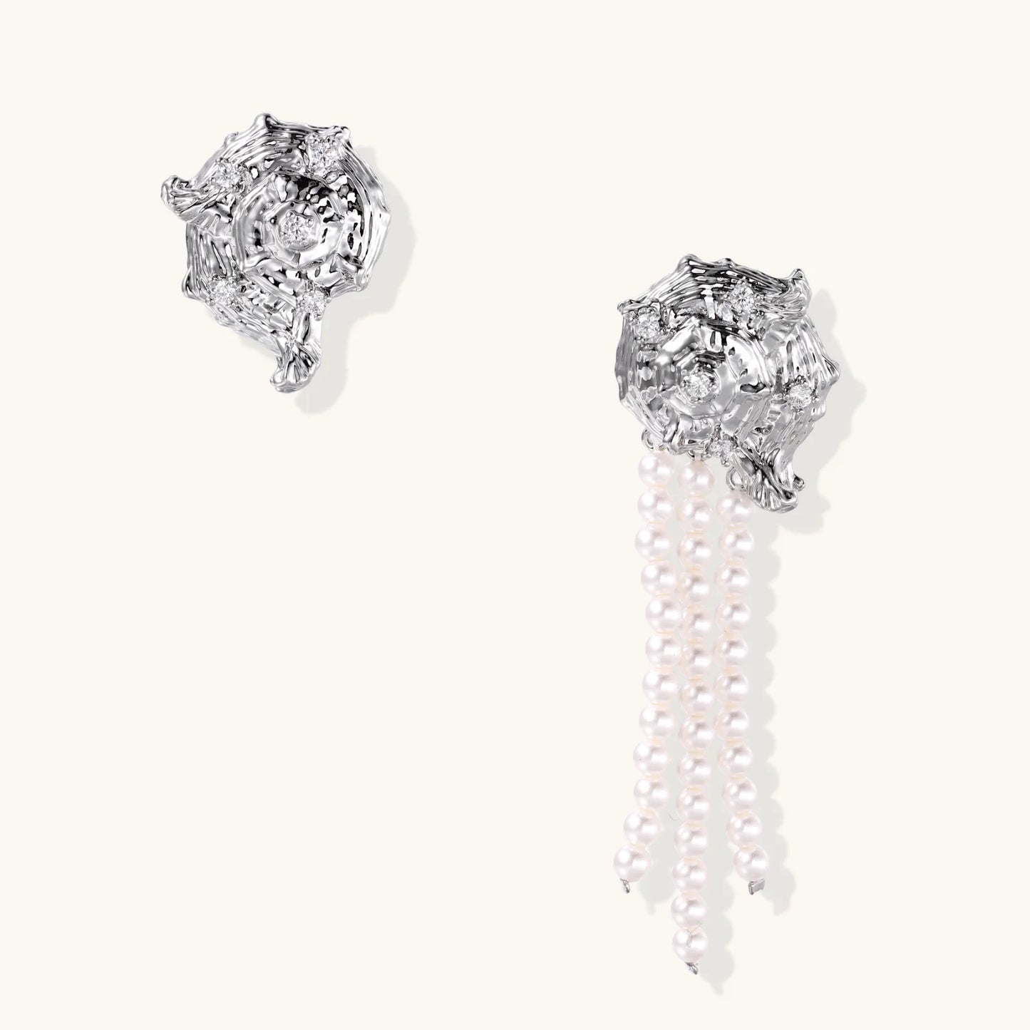 Silver-toned sculptural panther head earrings with zirconia details and white pearl drops on cream background