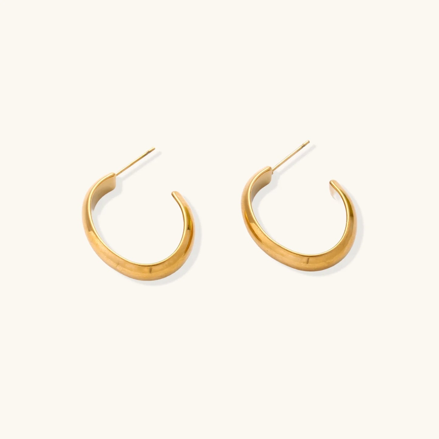Chunky brushed gold hoop earrings in 14K plated stainless steel on cream background, front and side view.