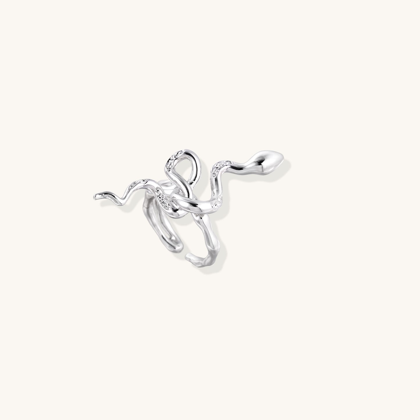 Gold-plated brass snake ring with flowing curves and crystal accents, wrapping around finger in sculptural design