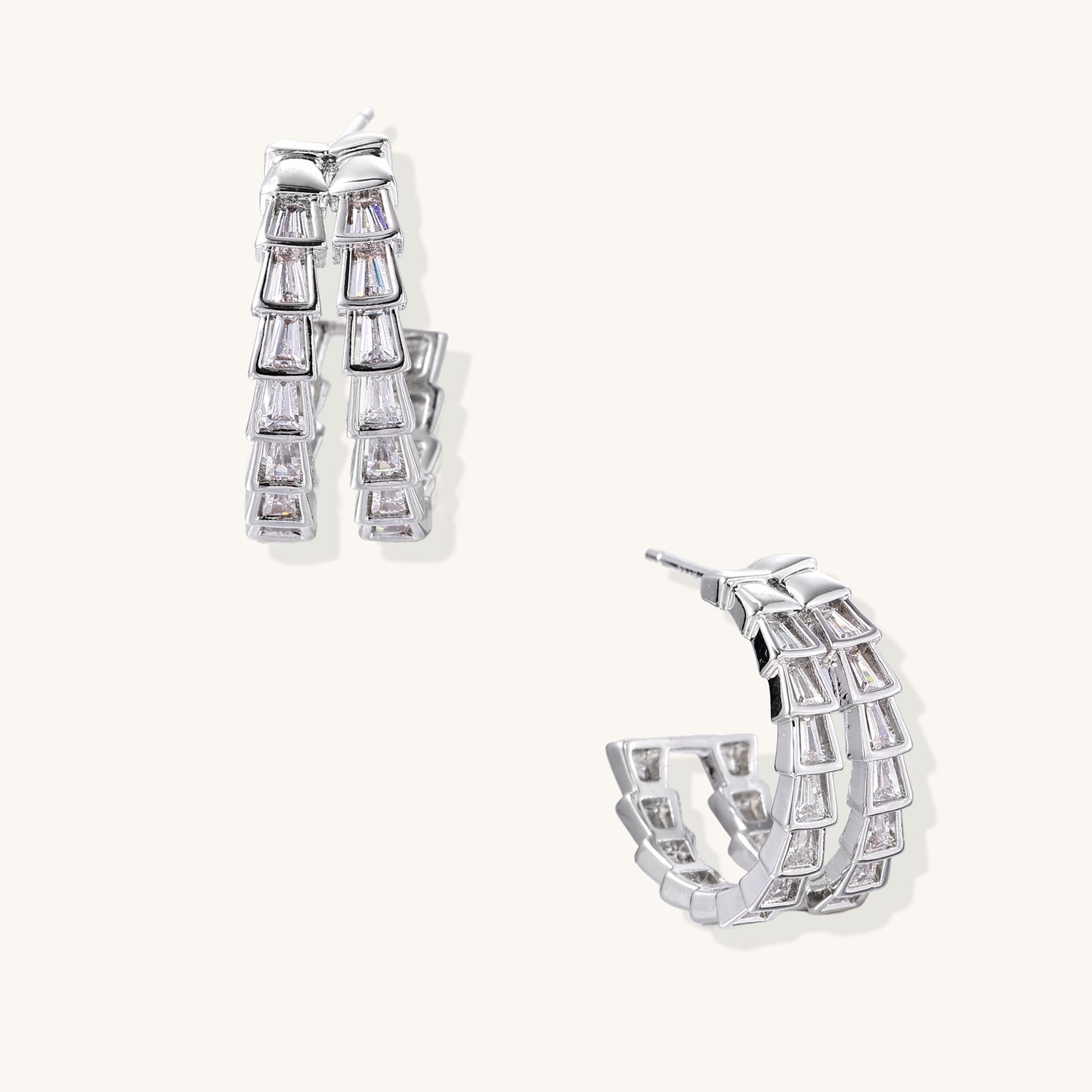 Gold-plated huggie hoops featuring vertical rows of clear baguette zirconia stones in geometric linear design