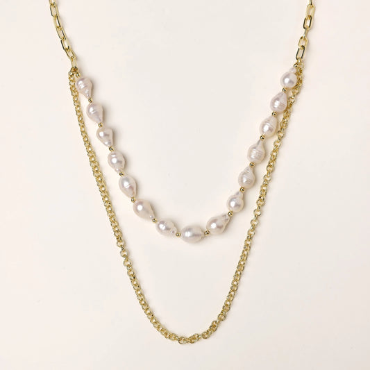 Layered gold chain necklace with irregular freshwater pearls on cream background, showing adjustable dual-strand design.