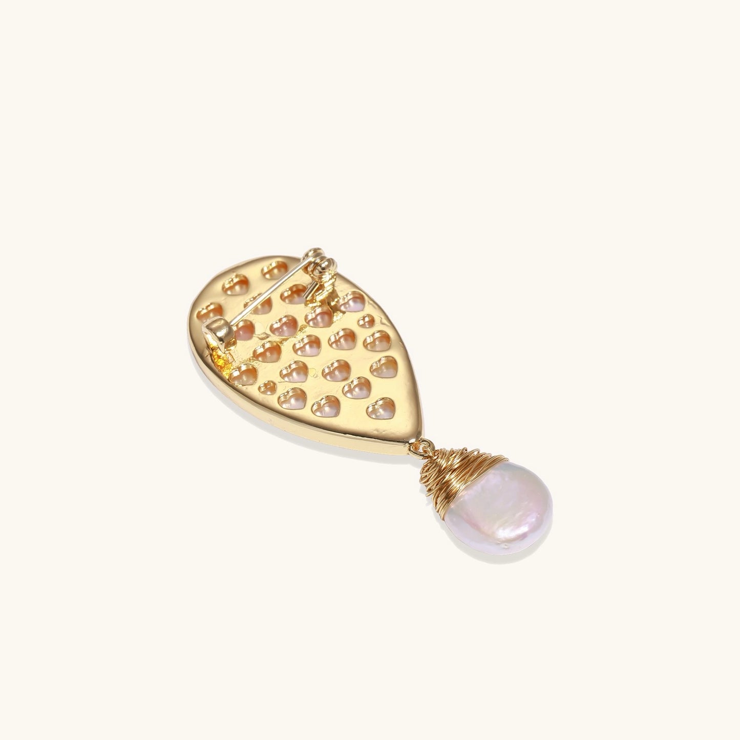 Teardrop-shaped pin with iridescent golden shell, small gold frog figure, and baroque pearl drop on white background.