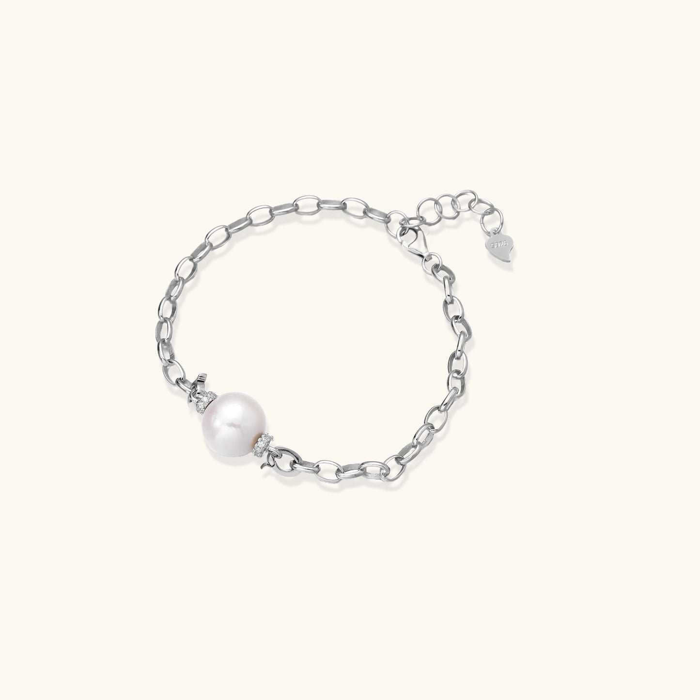 Dainty sterling silver chain bracelet with round freshwater pearl and crystal accents on white background.