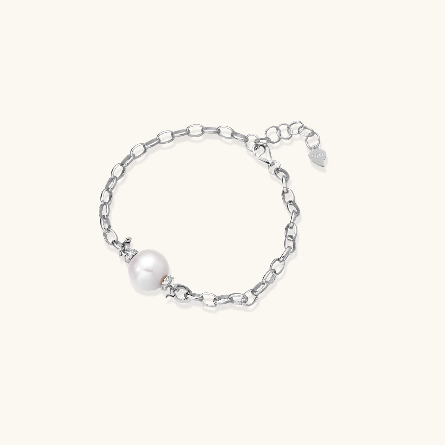 Dainty sterling silver chain bracelet with round freshwater pearl and crystal accents on white background.
