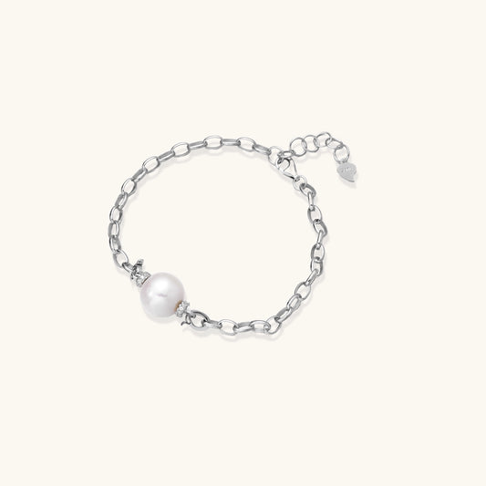 Dainty sterling silver chain bracelet with round freshwater pearl and crystal accents on white background.