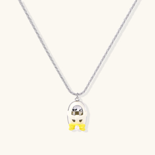 Minimalist gold plated brass necklace with cute capsule pendant featuring yellow bow detail on neutral background.