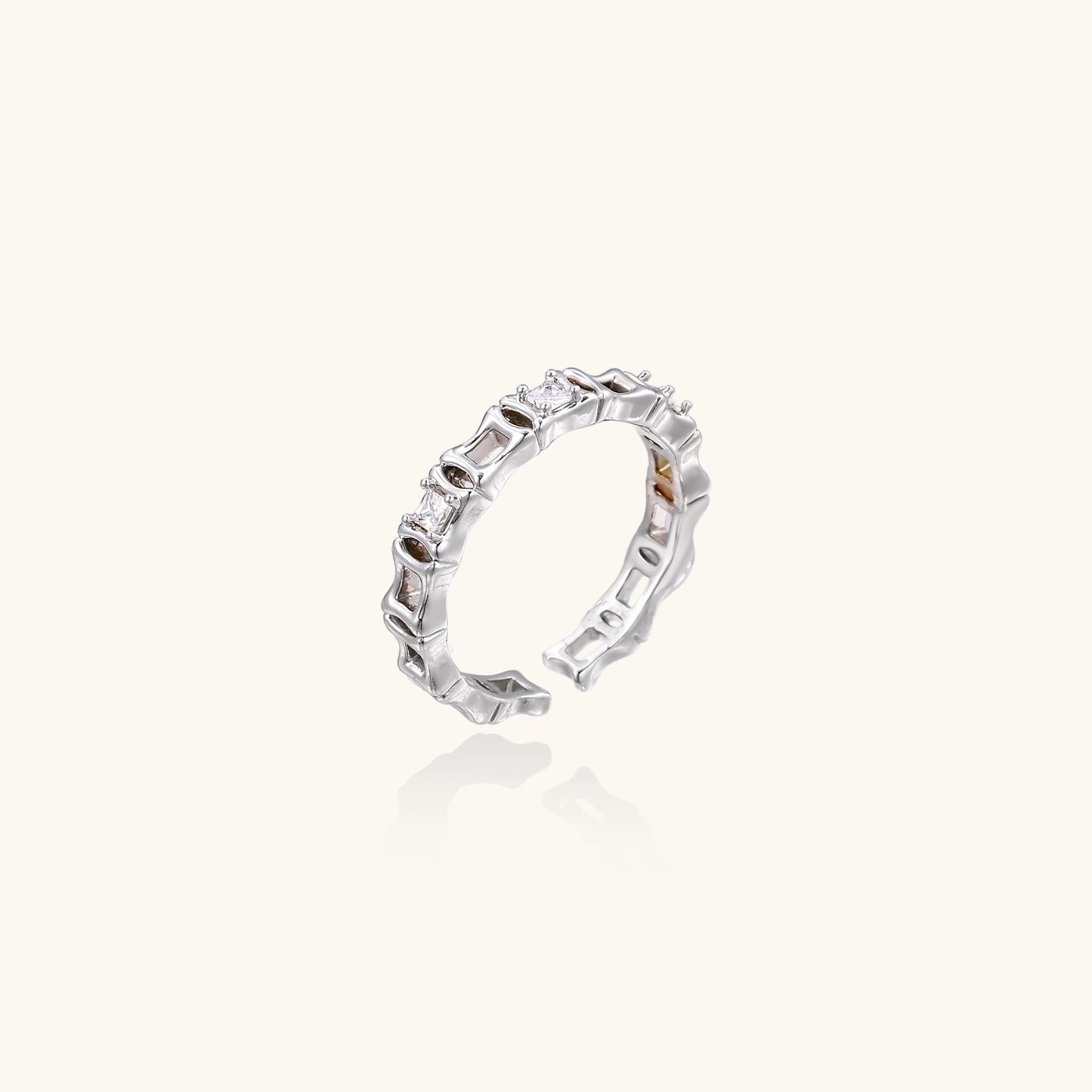 White gold plated ring with architectural lattice design and zirconia accents on cream background