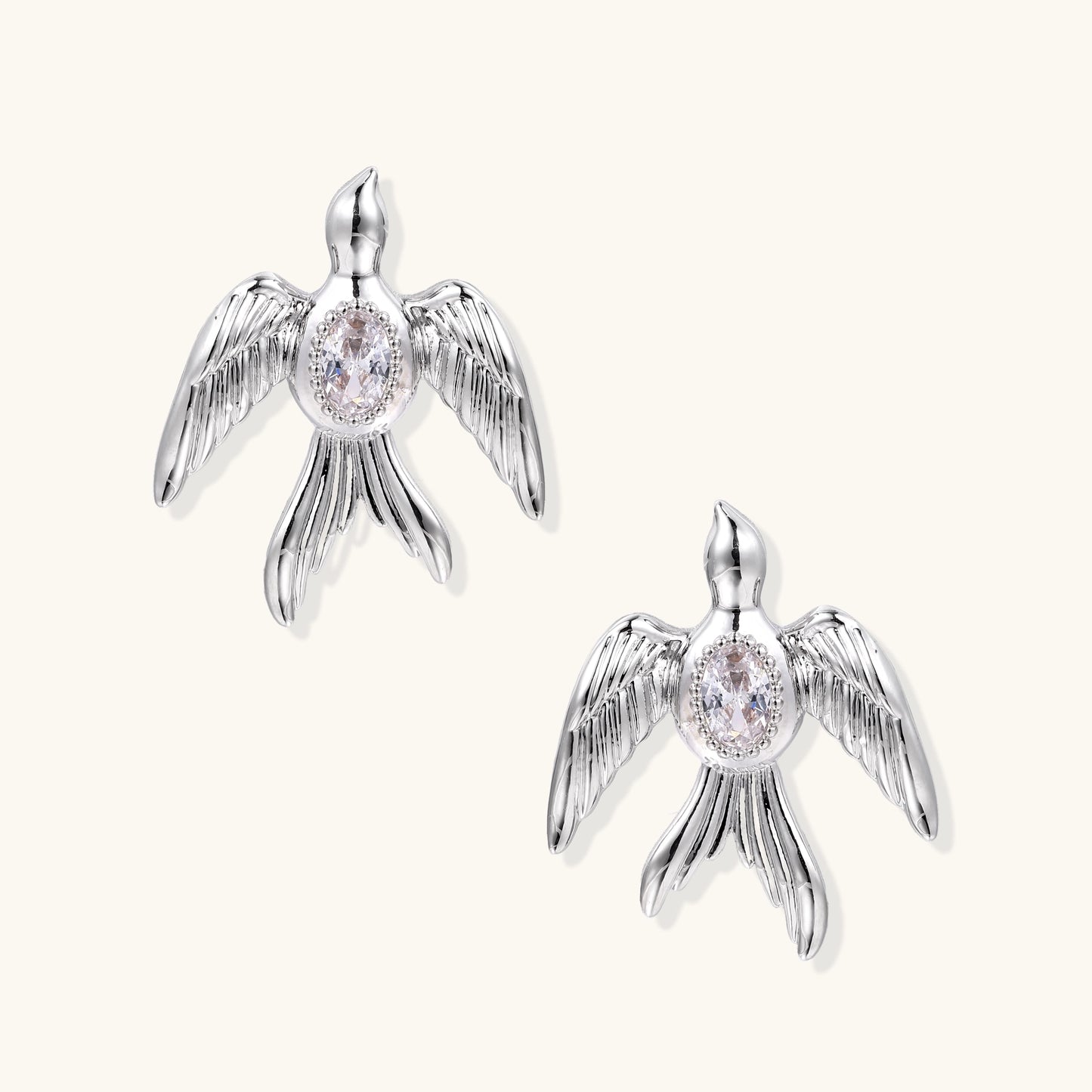 Gold-plated angel wing stud earrings with detailed feather texture and oval zirconia stones in centers