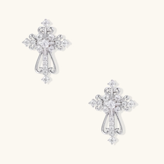 Ornate gold-plated cross dangle earrings with baroque scrollwork details and sparkling zirconia stones on neutral background
