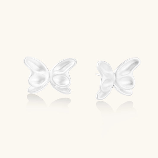 Delicate sterling silver butterfly stud earrings with intricate wing details on a neutral background.