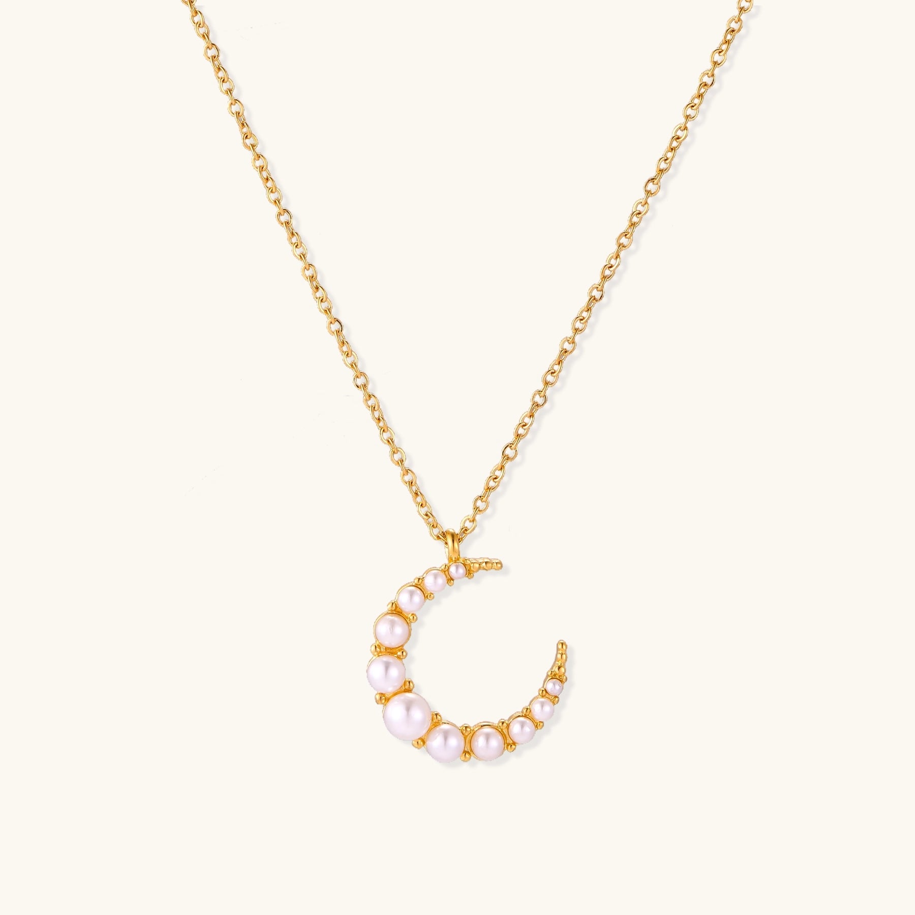 Delicate 18K gold plated necklace featuring crescent moon pendant with white shell pearl beads on neutral background.