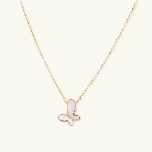 Delicate gold butterfly necklace with white mother of pearl wings on fine chain, displayed on neutral background.