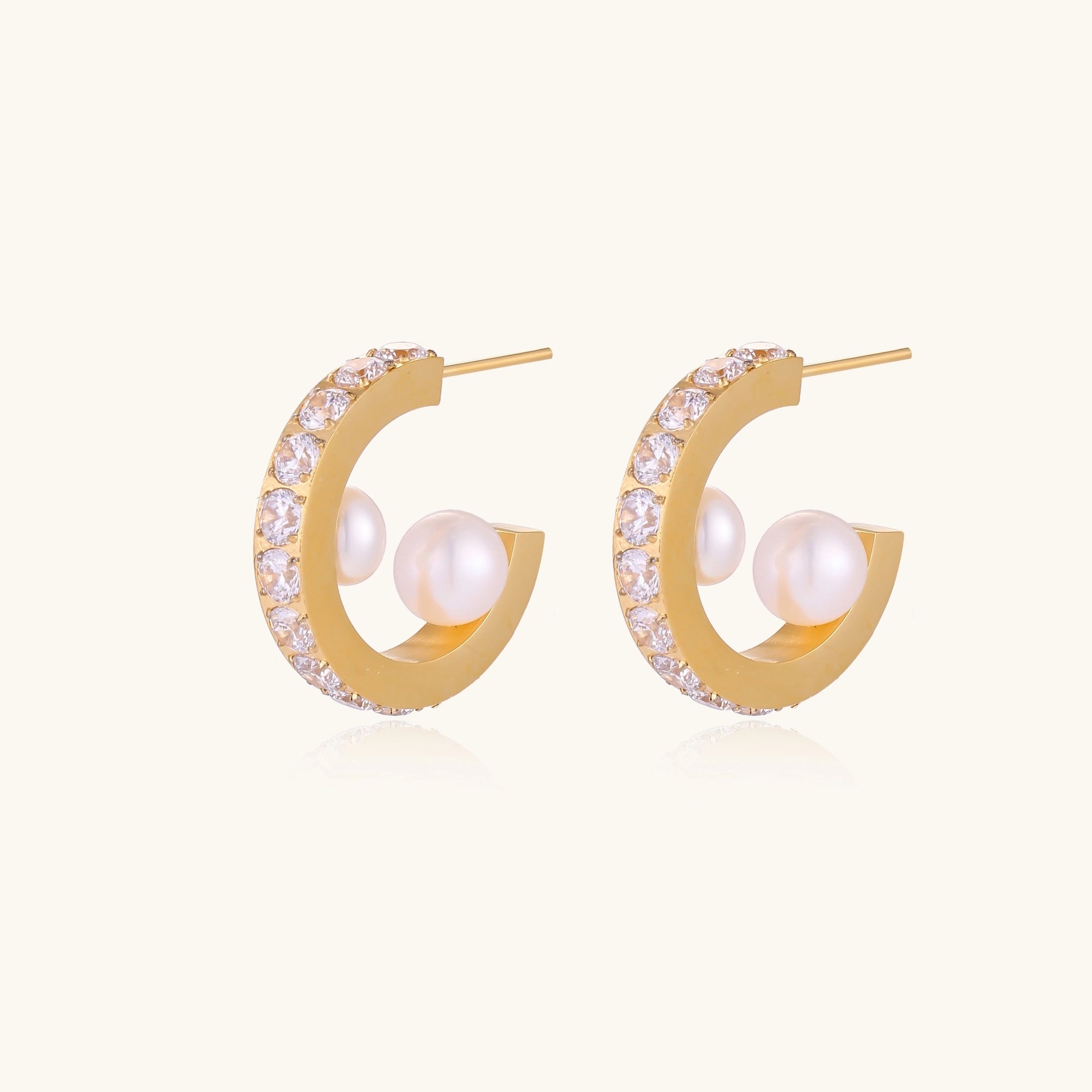 Gold-plated hoop earrings with crystal pavé and floating freshwater pearls inside the circular design.