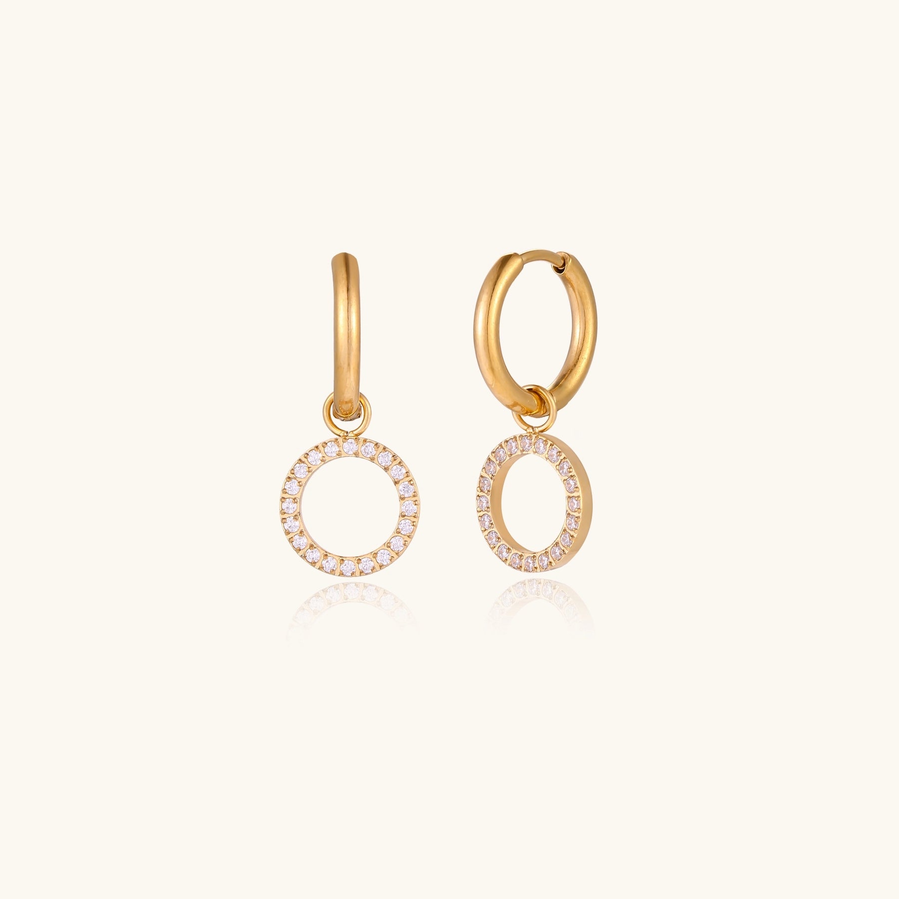 Gold-plated hoop earrings with circular cubic zirconia charm dangles displayed on neutral background.
