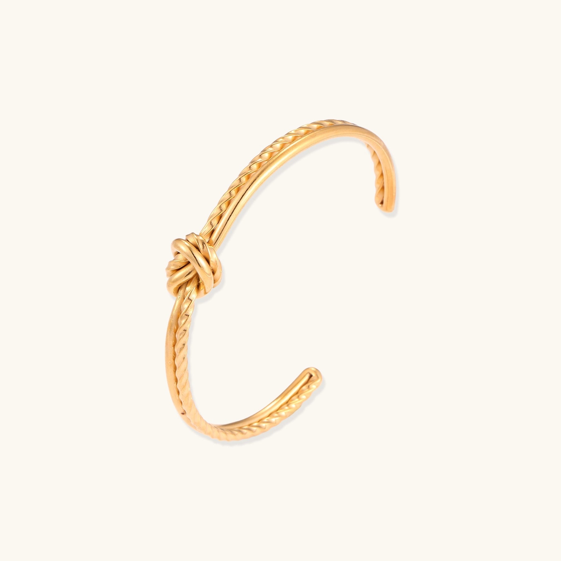 18K gold-plated twisted rope cuff bracelet with decorative knot detail on white background, showing adjustable open design.