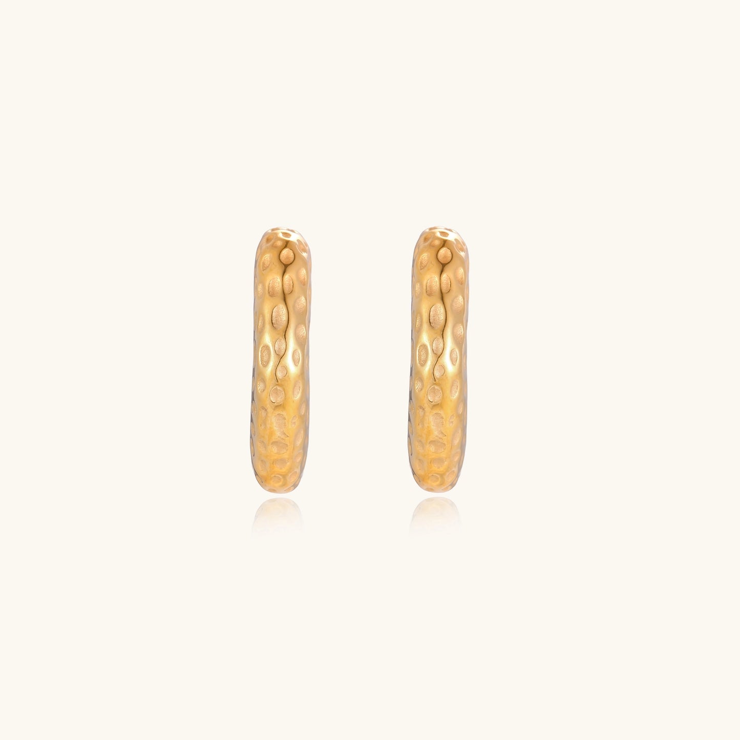 Textured gold-plated hoop earrings with dimpled surface pattern and post backs on neutral background.