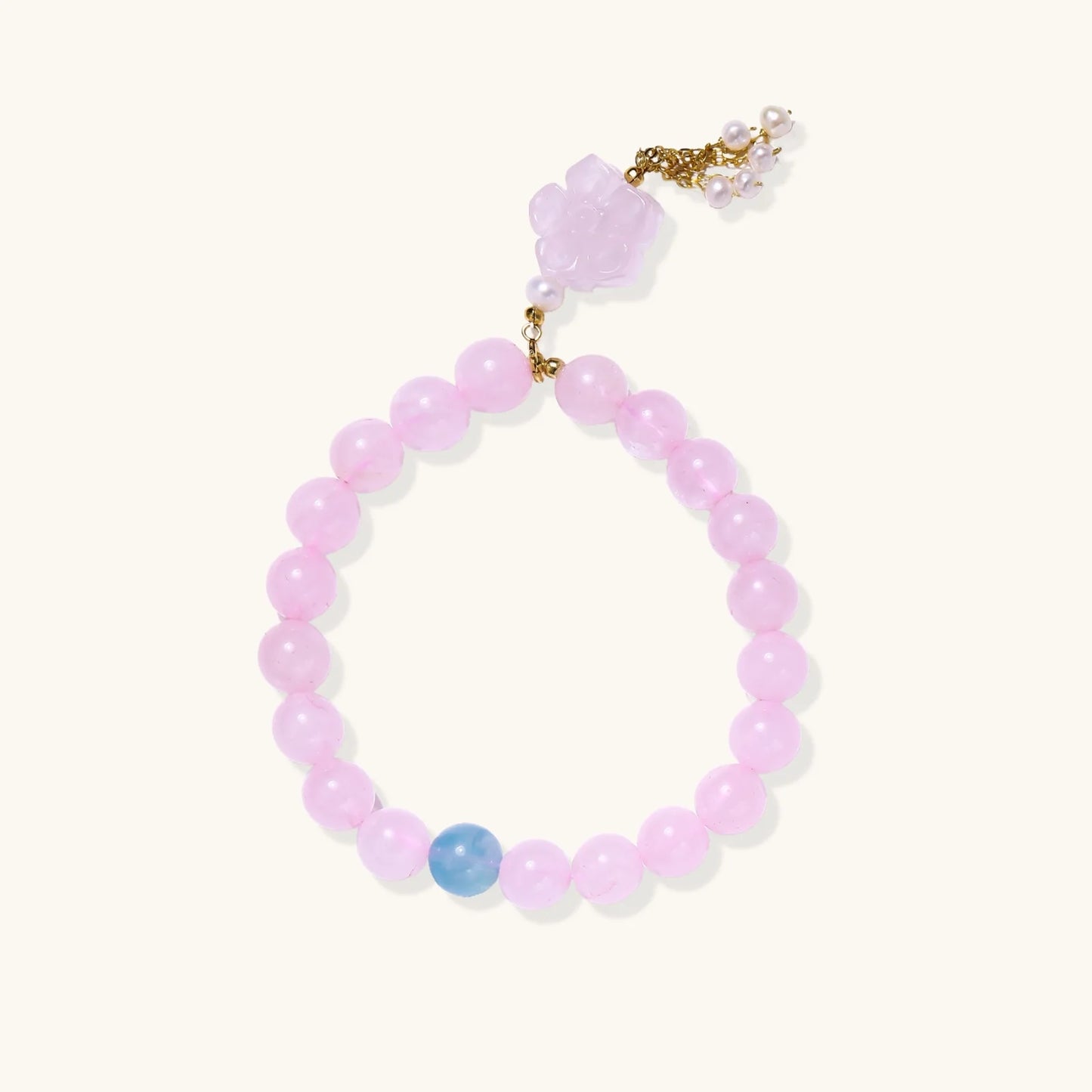 Stretchy beaded bracelet with pink rose quartz, blue aquamarine, carved floral pendant, and pearl tassel clasp.