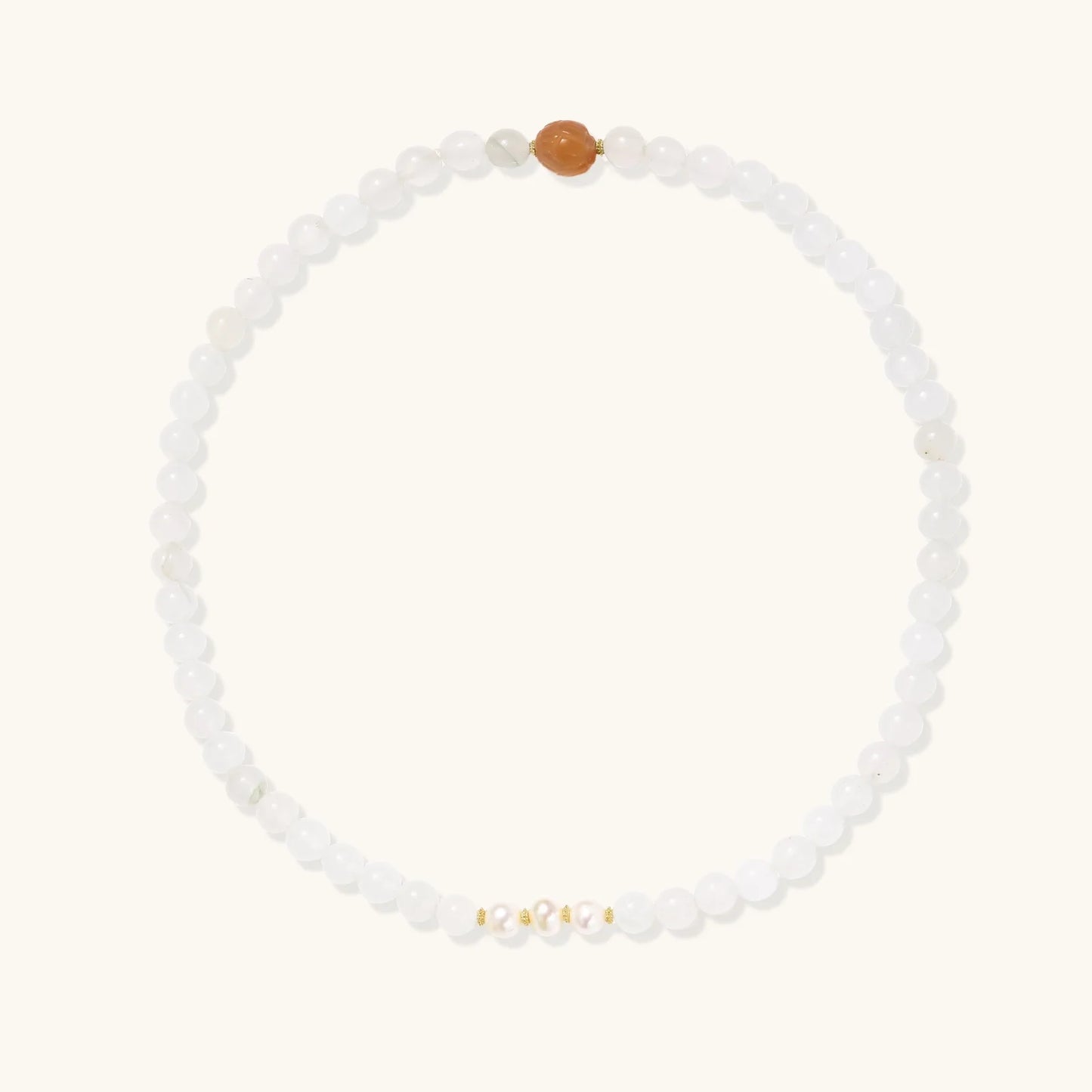 Three layered white beaded bracelets with carved orange agate lotus centerpiece and freshwater pearls on cream background.