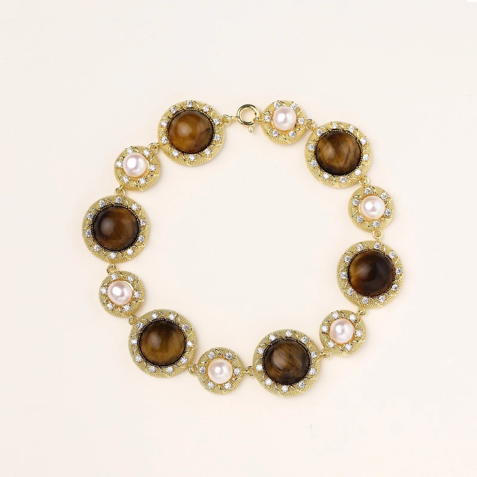 Gold-plated link bracelet with alternating brown tiger's eye stones and white freshwater pearls in ornate bezels.