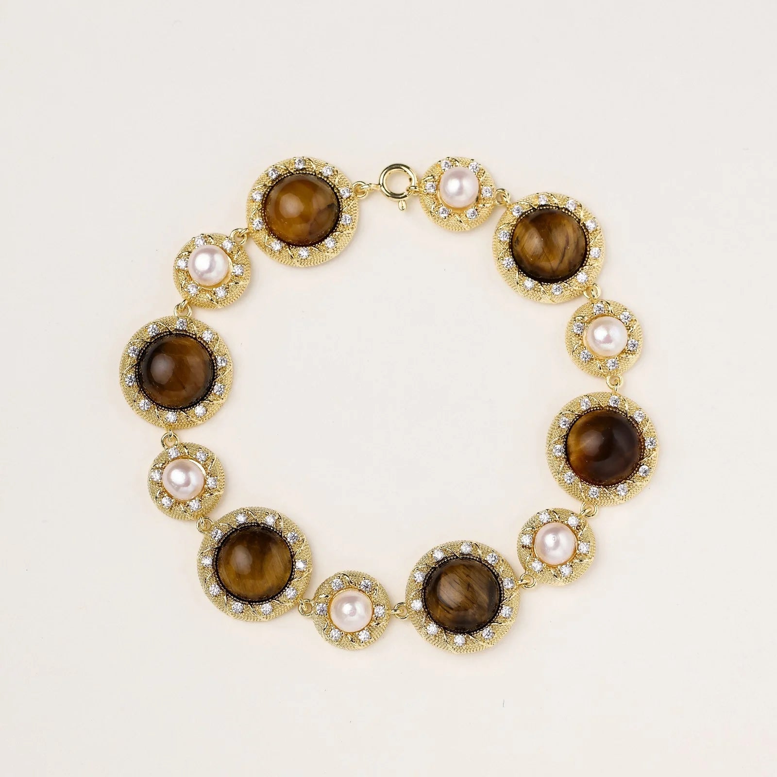 Gold-plated link bracelet with alternating brown tiger's eye stones and white freshwater pearls in ornate bezels.
