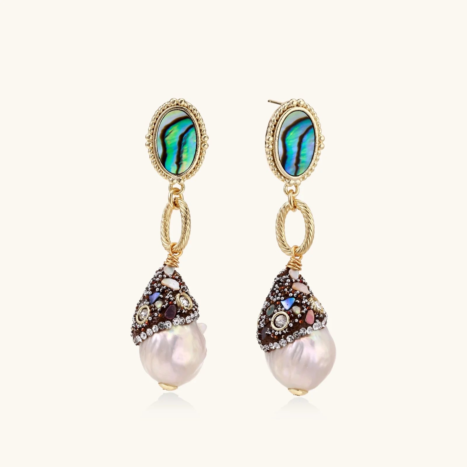 Gold drop earrings with iridescent abalone studs, rope links, jeweled caps and white baroque pearls on cream background