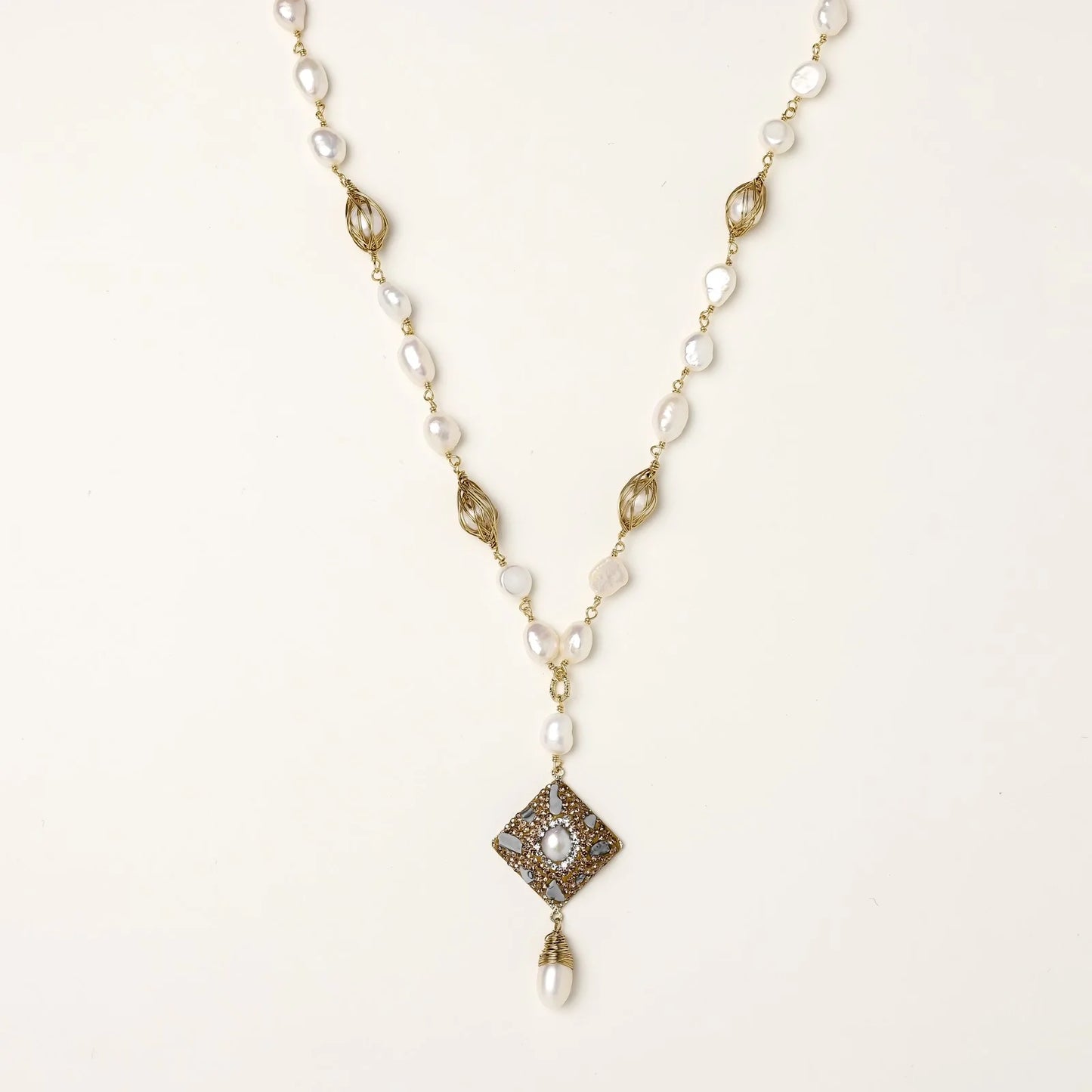 Y-shaped necklace with freshwater pearls, gold filigree stations, and ornate diamond-shaped centerpiece with pearl drop
