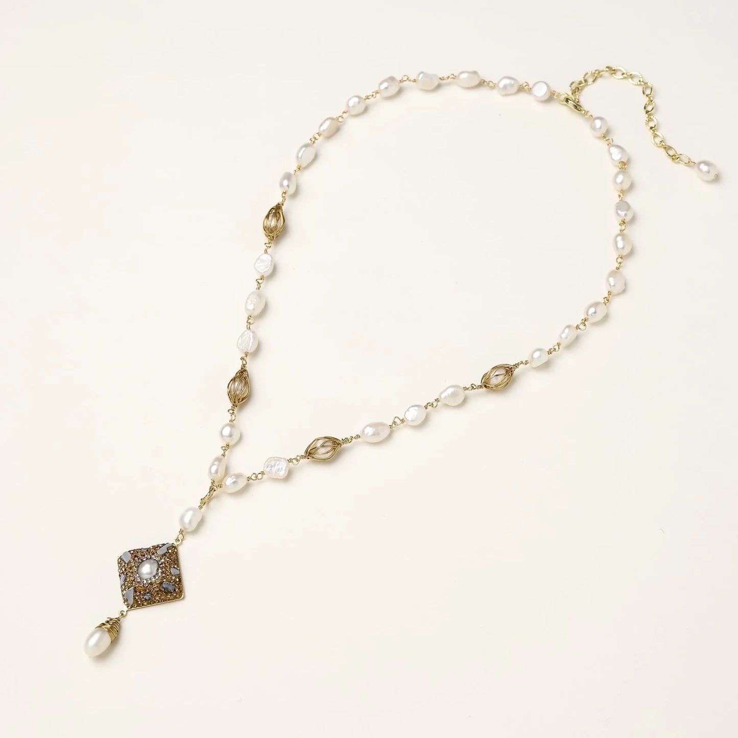 Y-shaped necklace with freshwater pearls, gold filigree stations, and ornate diamond-shaped centerpiece with pearl drop