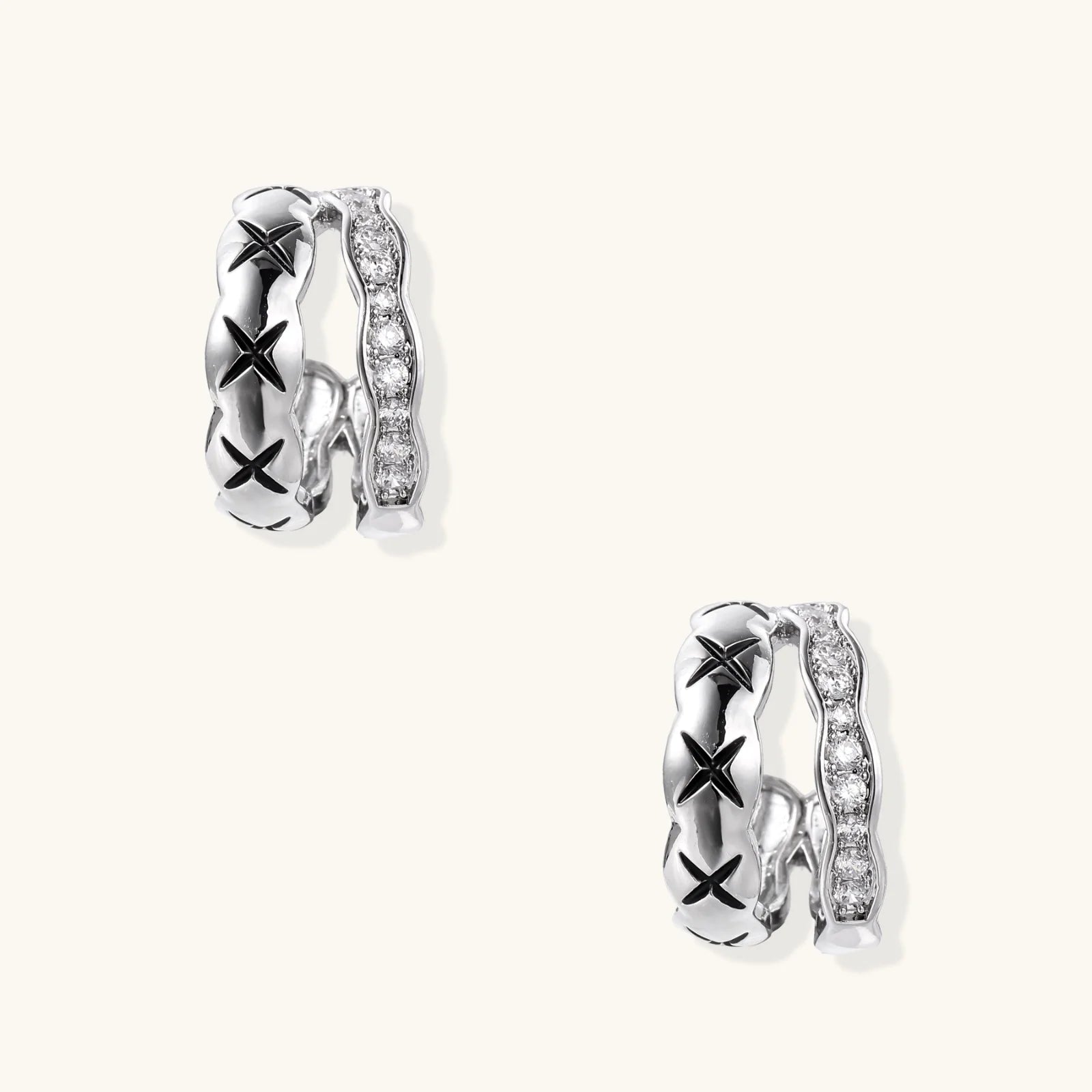 Triple-row white gold hoops with black X-pattern, twisted band, and pavé zirconia stones on white background.
