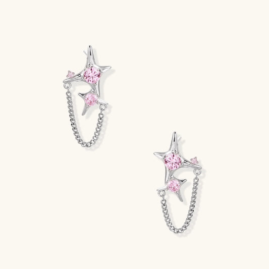 Pair of silver star-shaped ear climbers with pink zirconia stones connected by delicate chains