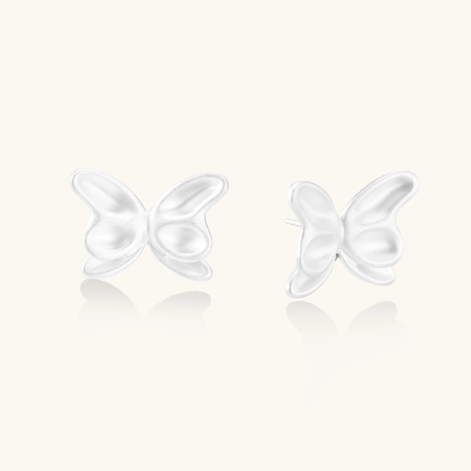 Pair of translucent butterfly-shaped stud earrings with frosted finish and dimensional wing details on white background