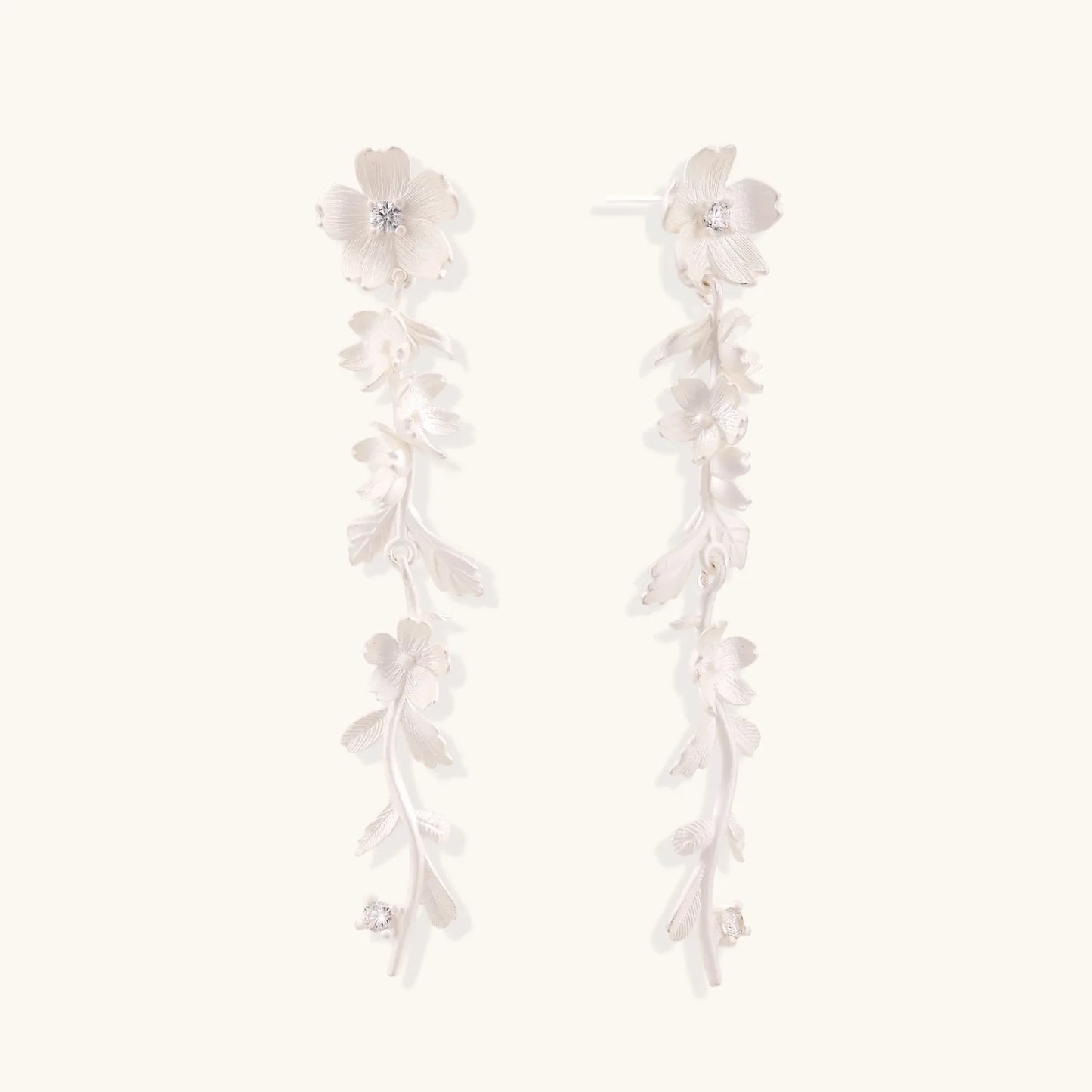 Long sterling silver drop earrings with delicate floral vine design and crystal accents on white background