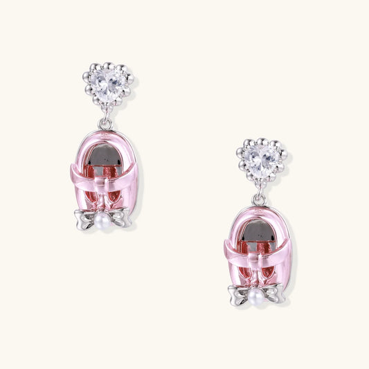 Drop earrings featuring miniature translucent handbag charms with heart crystal studs, silver bow accents, and pearls