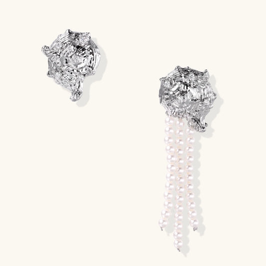 Silver-toned sculptural panther head earrings with zirconia details and white pearl drops on cream background