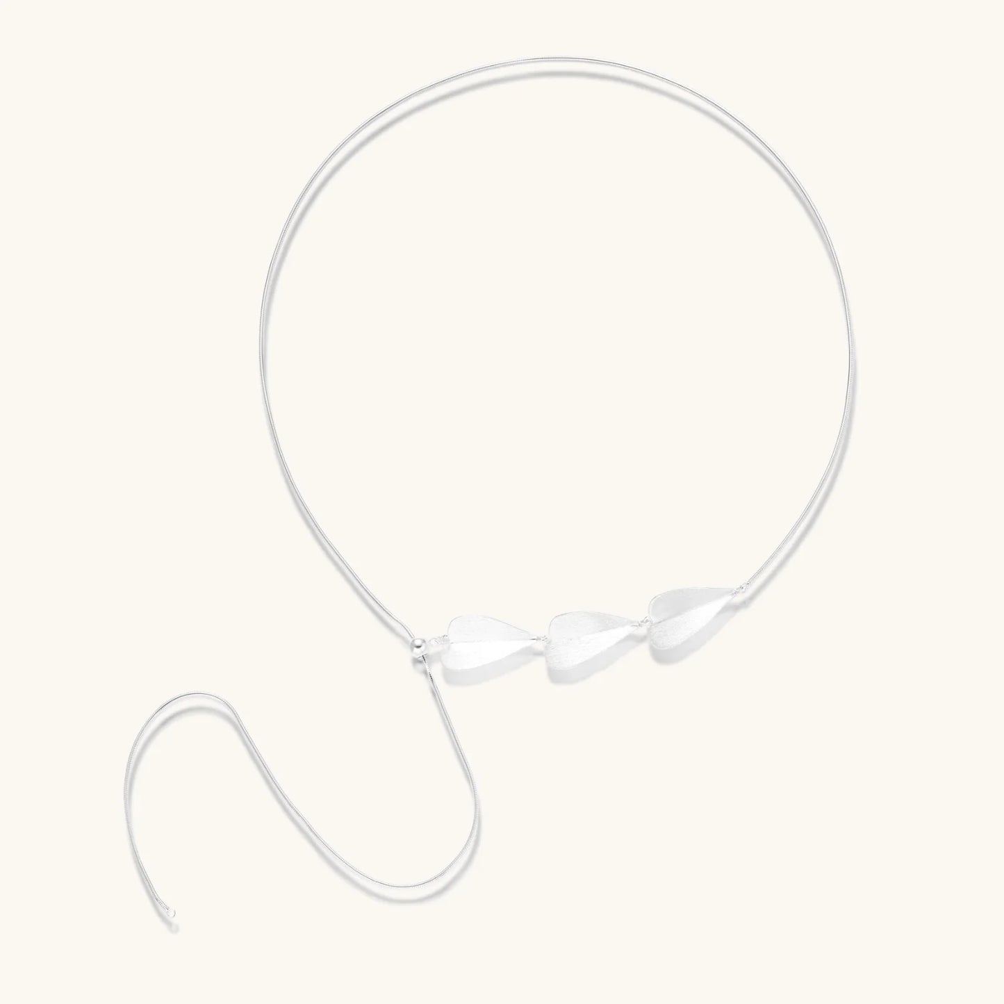 Minimalist sterling silver necklace with three brushed leaf-shaped pendants on delicate chain against white background