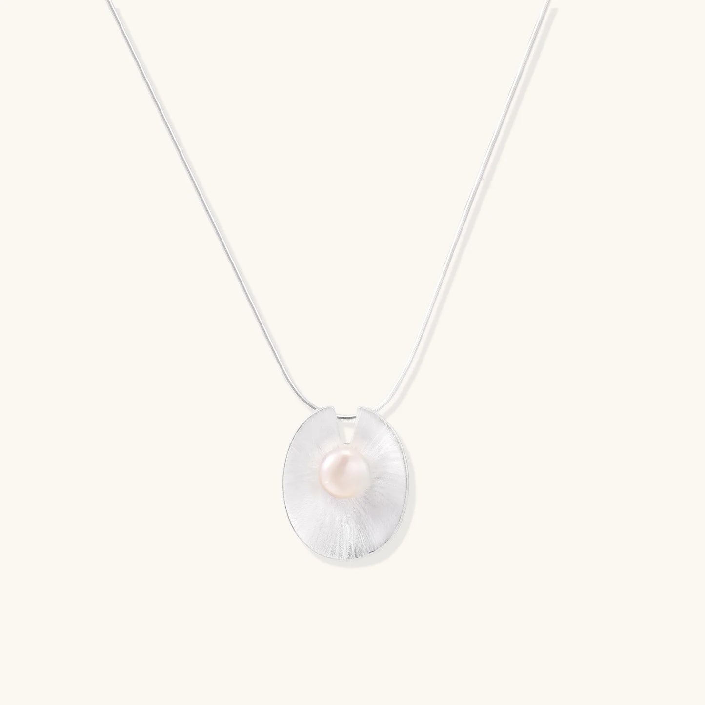 Sterling silver disc necklace with textured finish and centered freshwater pearl on delicate chain