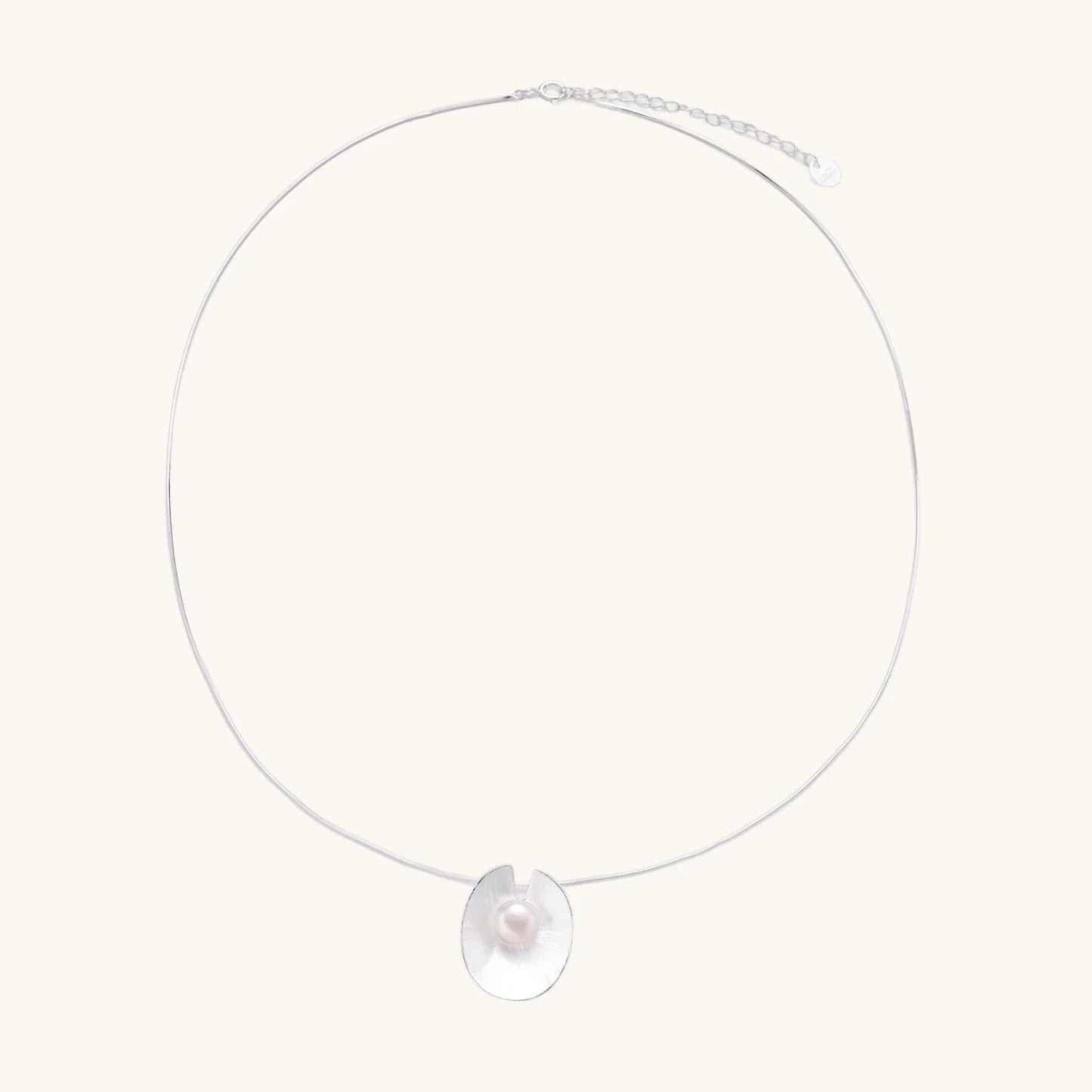 Sterling silver disc necklace with textured finish and centered freshwater pearl on delicate chain