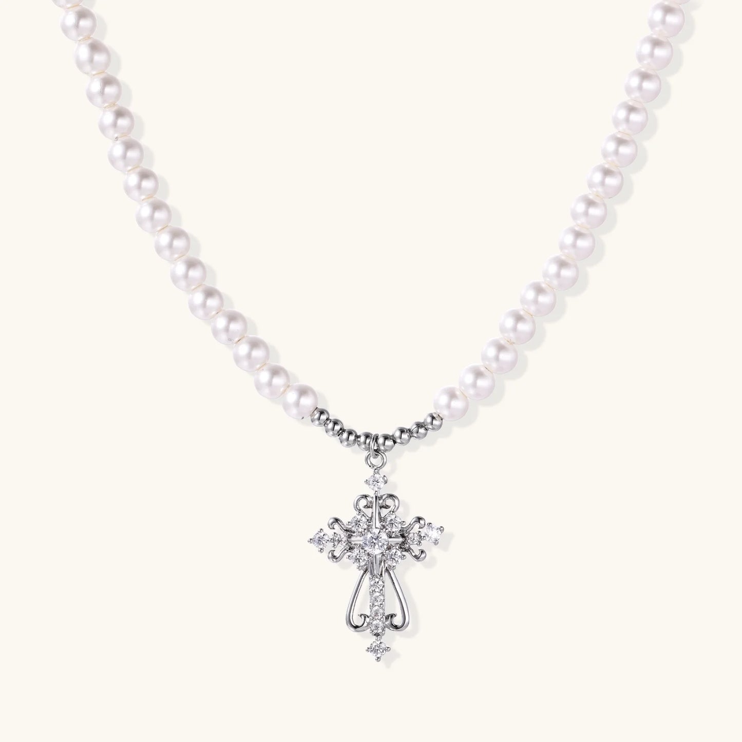 White pearl beaded necklace with ornate crystal-embellished cross pendant on white background, white gold plated finish