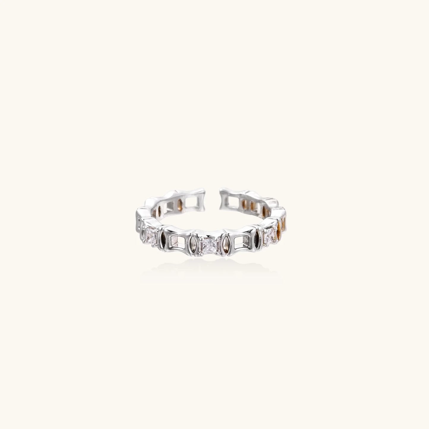 White gold plated ring with architectural lattice design and zirconia accents on cream background