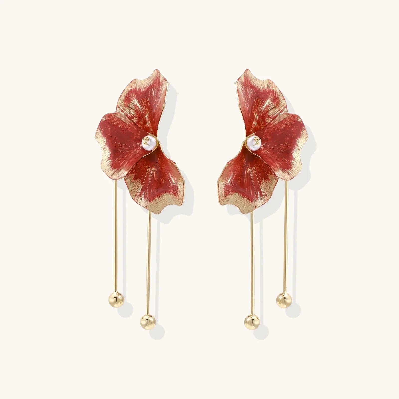 Red enamel flower earrings with gold-plated stems, central pearl, and gradient coral-to-gold petals on white background