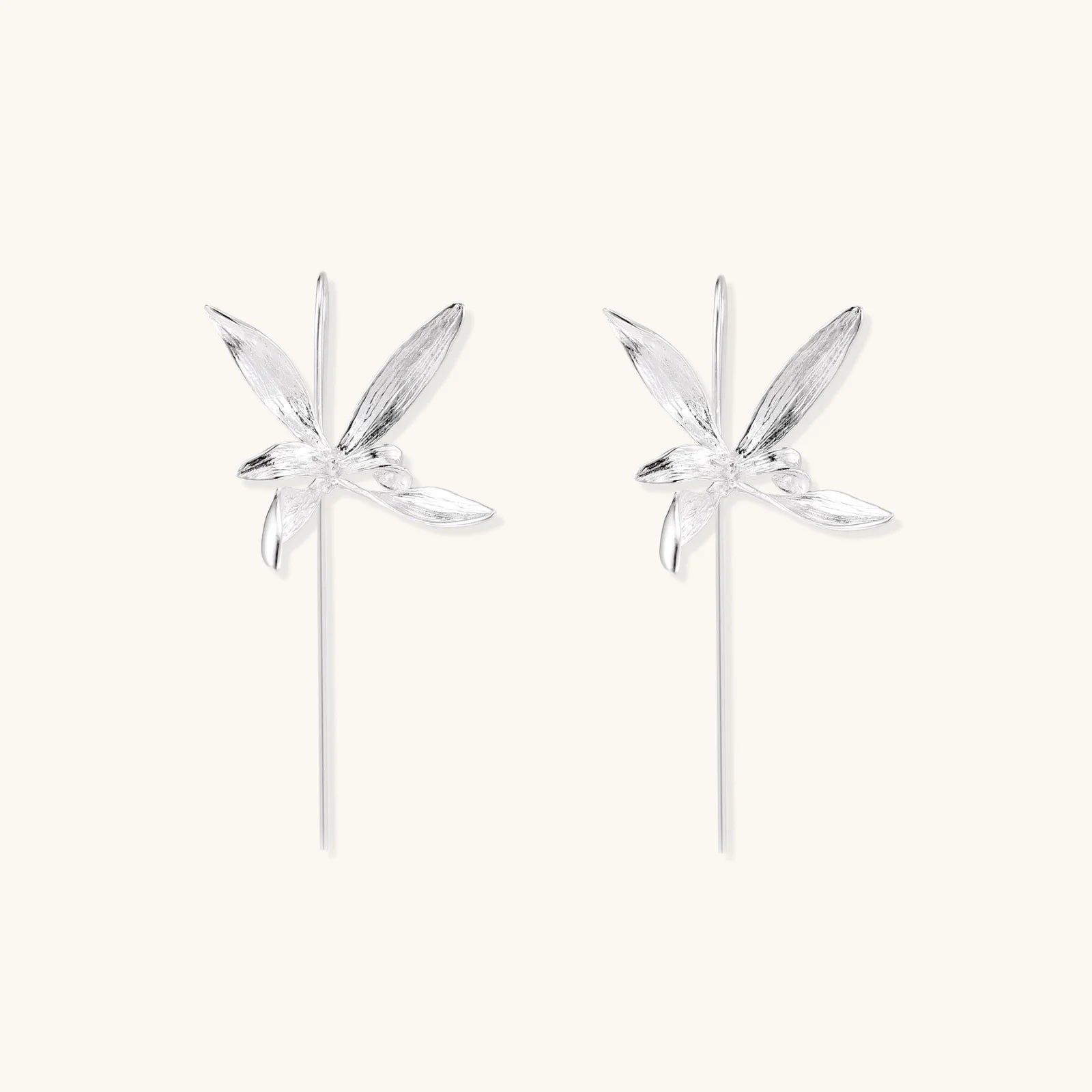 Delicate sterling silver dragonfly earrings with textured wings and curved threader hooks on white background