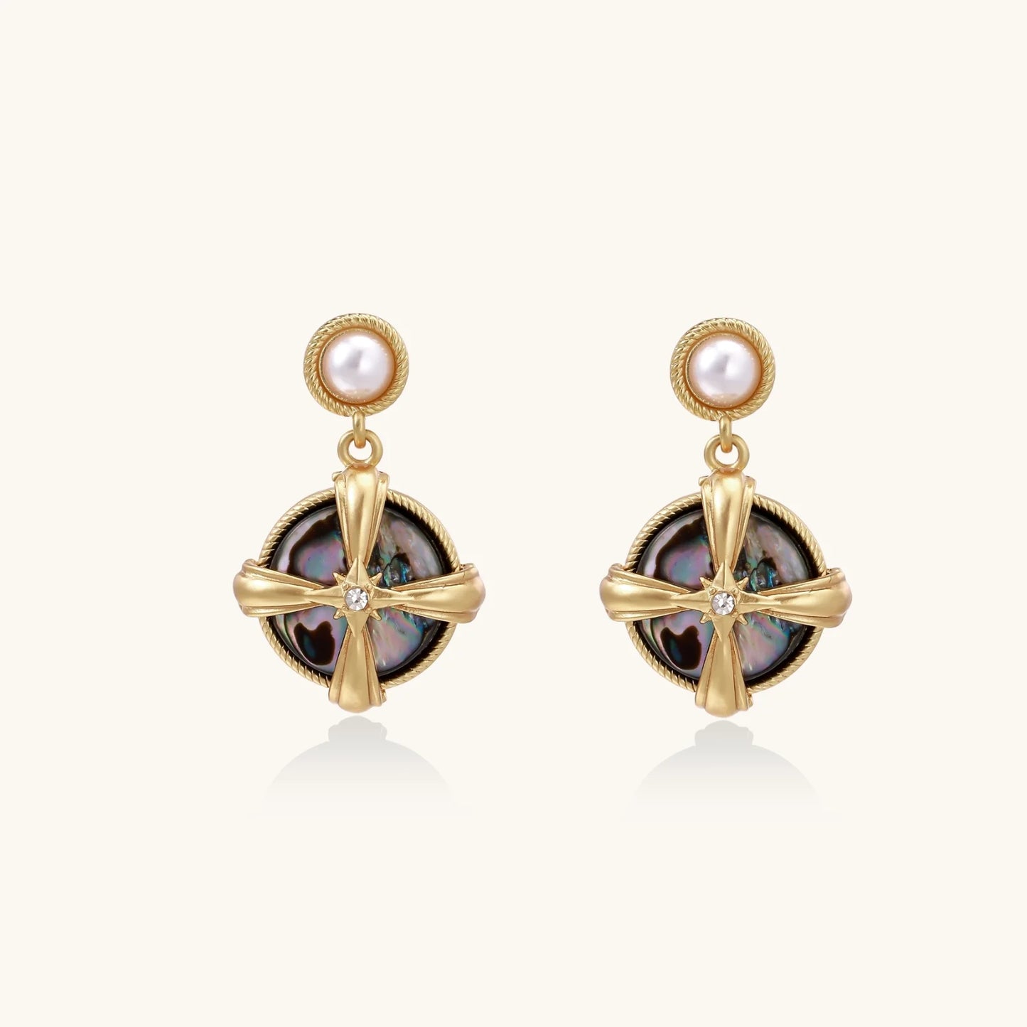 Gold-plated drop earrings with iridescent abalone shell and pearl studs in geometric cross design