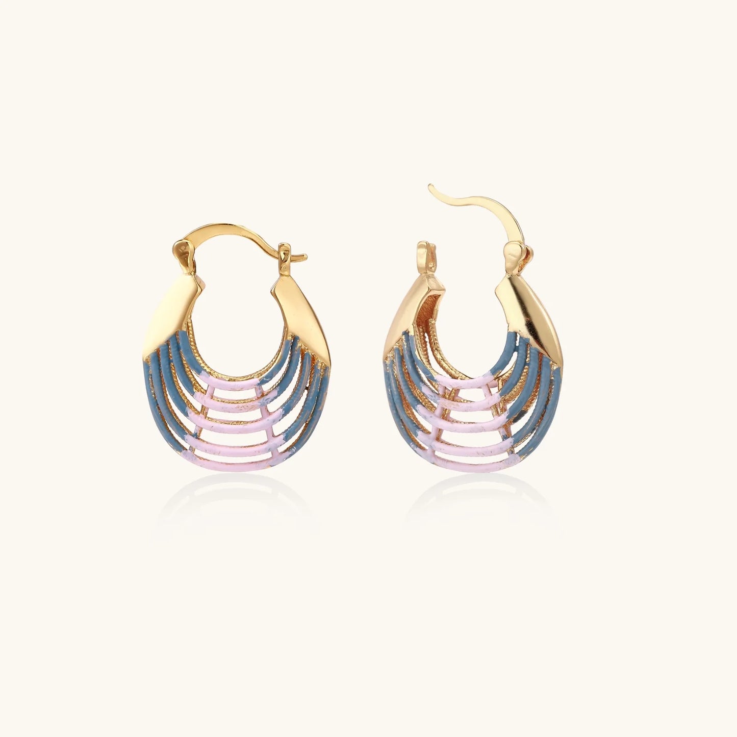 Gold hoop earrings with gradient blue-to-pink enamel in ribbed fan design on beige background