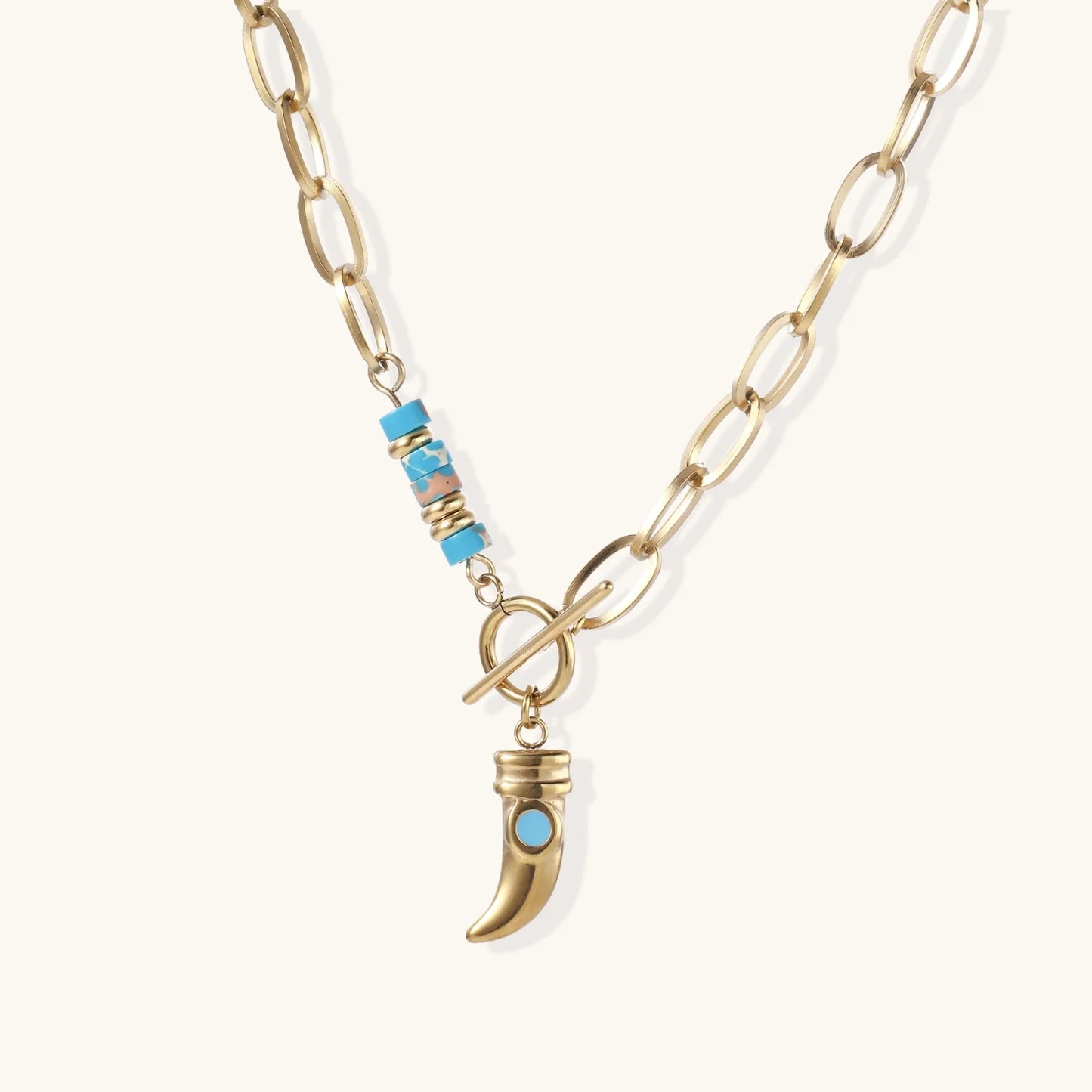 Gold chunky chain necklace with turquoise beaded accent and horn pendant on white background