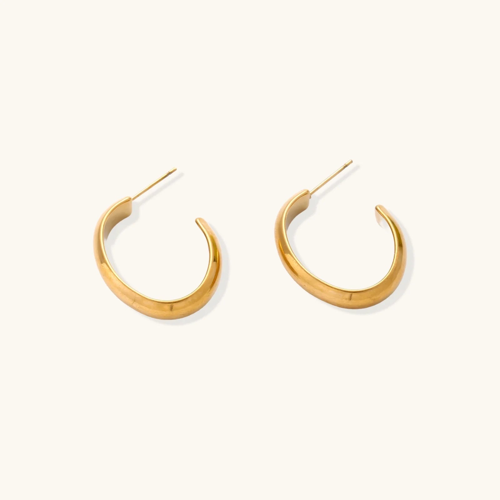 Chunky brushed gold hoop earrings in 14K plated stainless steel on cream background, front and side view.